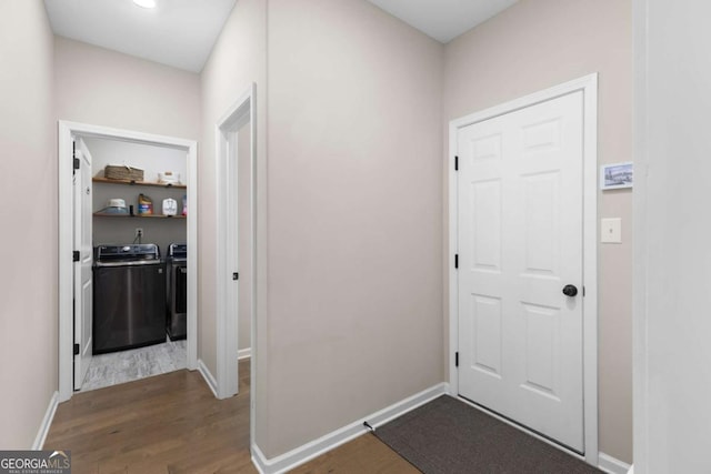 interior space with washing machine and clothes dryer and hardwood / wood-style floors