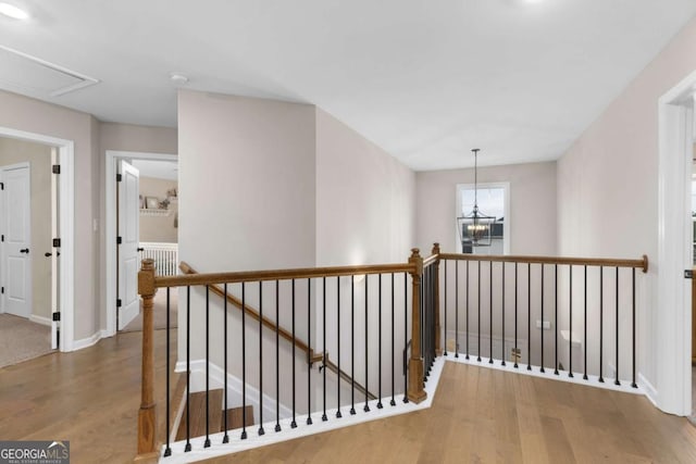 hallway featuring hardwood / wood-style flooring and a chandelier