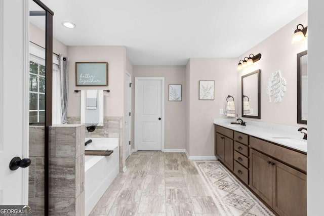 bathroom with vanity and a bath