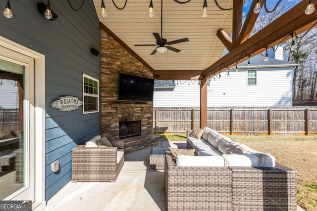 view of patio / terrace with ceiling fan and an outdoor living space with a fireplace