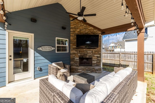 view of patio featuring ceiling fan and an outdoor living space with a fireplace