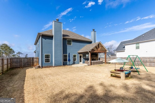 rear view of house with a gazebo, a playground, and a patio area