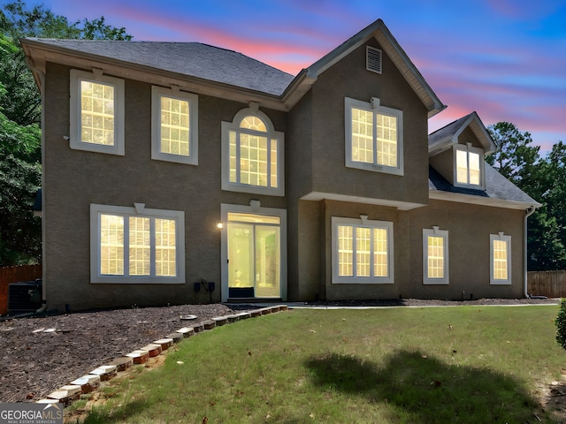 view of front facade with central AC and a lawn