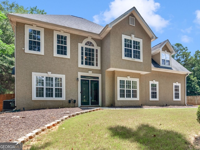 view of front facade featuring central AC and a front yard