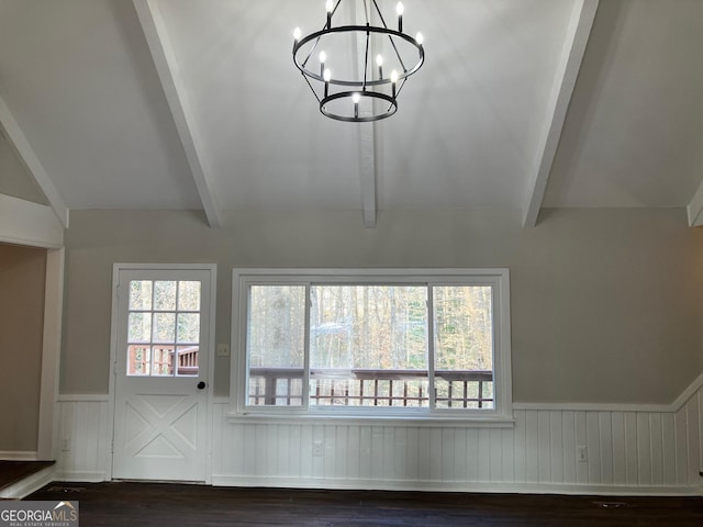 unfurnished living room with dark hardwood / wood-style floors, a healthy amount of sunlight, vaulted ceiling with beams, and a chandelier