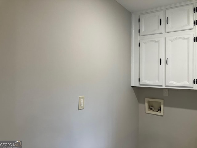 clothes washing area featuring hookup for a washing machine and cabinets