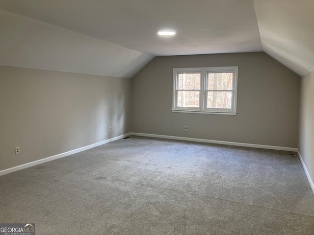 additional living space with vaulted ceiling and carpet