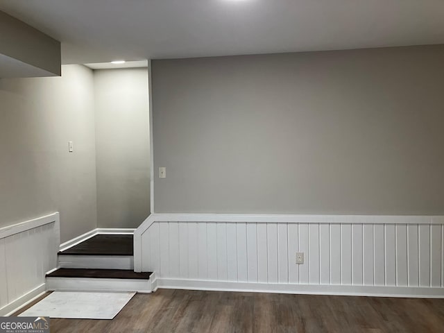 stairs with hardwood / wood-style floors and radiator heating unit