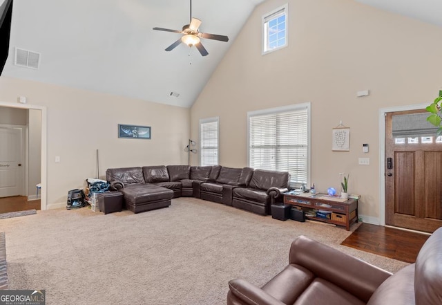 living room featuring carpet flooring, a wealth of natural light, and high vaulted ceiling