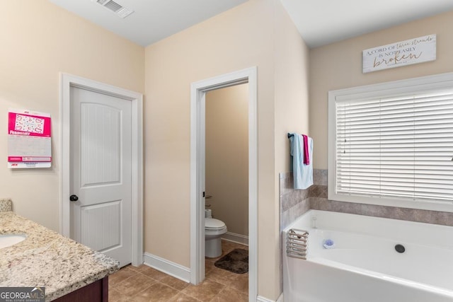 bathroom with vanity, toilet, tile patterned flooring, and a washtub