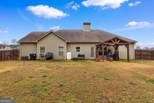 rear view of house with a gazebo, a yard, and cooling unit