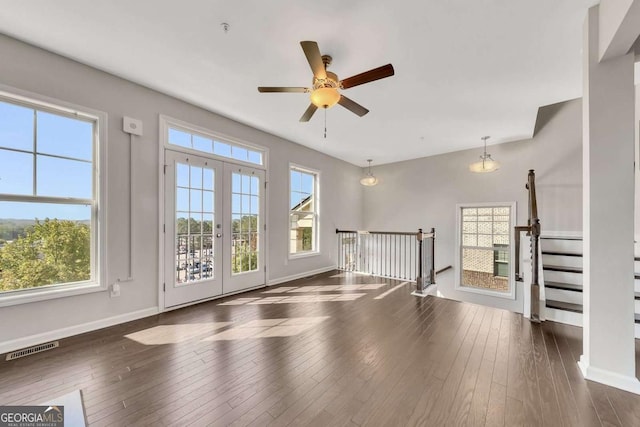 unfurnished living room featuring dark wood-type flooring, french doors, and ceiling fan