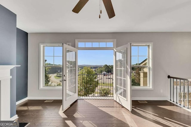 doorway featuring dark wood-type flooring, ceiling fan, and french doors