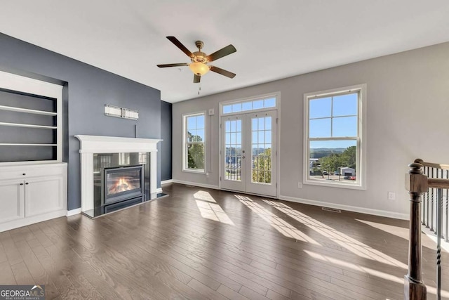 unfurnished living room with french doors, ceiling fan, and dark hardwood / wood-style flooring