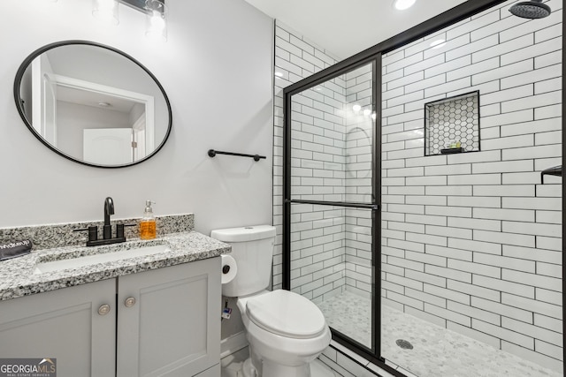 bathroom with vanity, an enclosed shower, and toilet