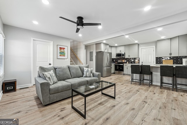 living room featuring ceiling fan and light hardwood / wood-style flooring