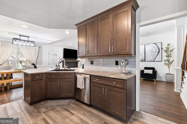 kitchen featuring sink, decorative backsplash, dishwasher, and light wood-type flooring