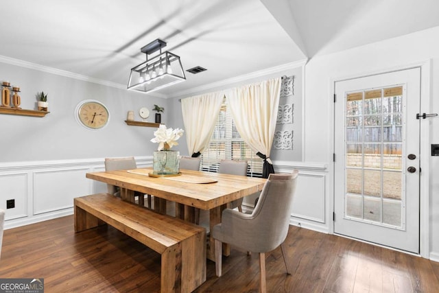 dining area with crown molding, dark wood-type flooring, and a wealth of natural light