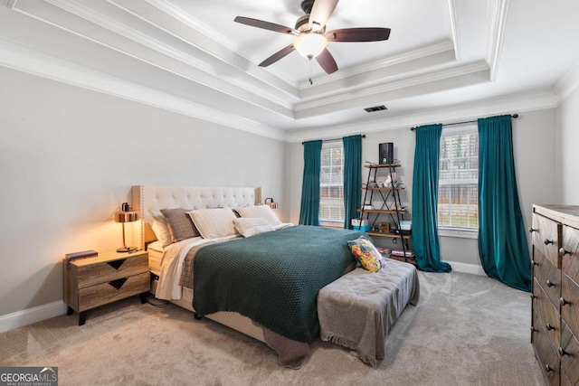 bedroom featuring ornamental molding, light colored carpet, ceiling fan, and a tray ceiling