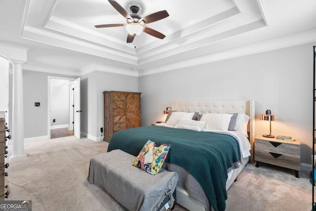 carpeted bedroom with ornamental molding, decorative columns, a raised ceiling, and ceiling fan