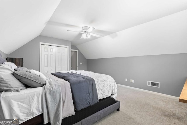 bedroom with ceiling fan, lofted ceiling, carpet floors, and a closet