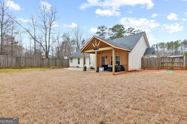 back of house with a patio and a lawn