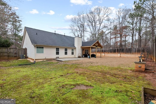 rear view of house with a yard, central AC unit, and a patio area