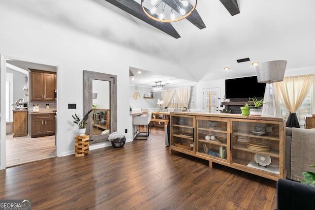 living room with dark hardwood / wood-style flooring, lofted ceiling, and an inviting chandelier