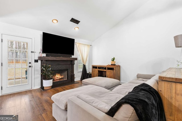 bedroom with access to exterior, lofted ceiling, dark hardwood / wood-style floors, and a tile fireplace