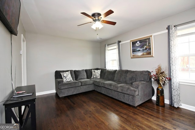 living room with ceiling fan and dark wood-type flooring