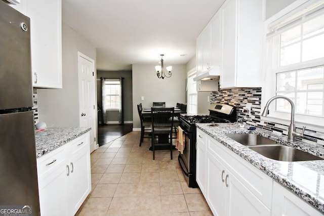 kitchen with sink, white cabinetry, range with gas stovetop, decorative light fixtures, and stainless steel refrigerator