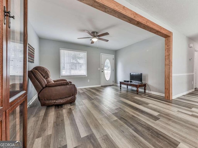 sitting room with hardwood / wood-style floors and ceiling fan