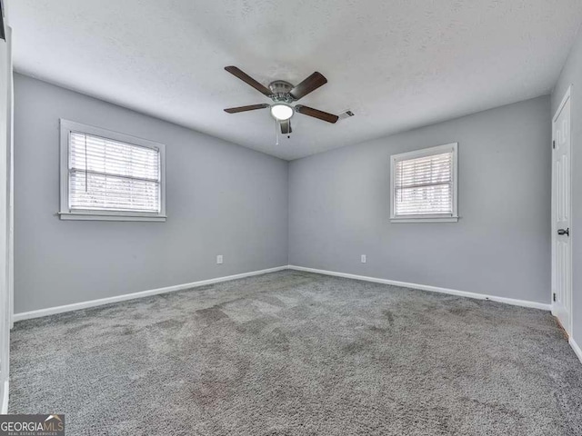 carpeted spare room with ceiling fan and a textured ceiling