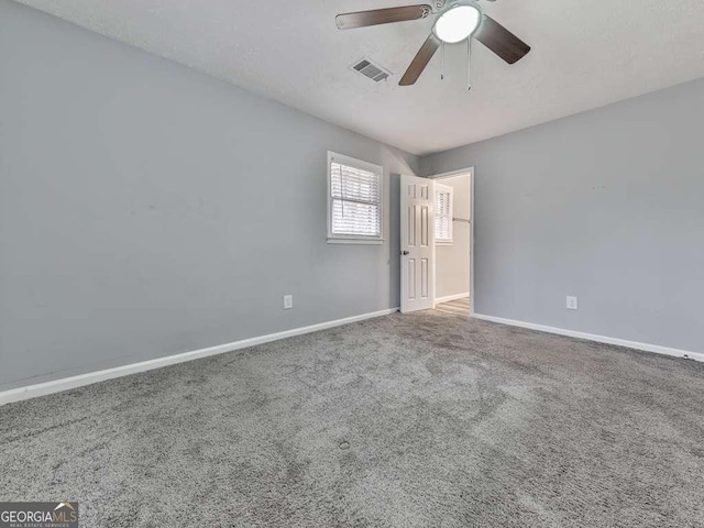 carpeted spare room featuring ceiling fan