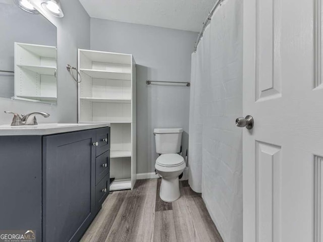 bathroom featuring wood-type flooring, vanity, and toilet