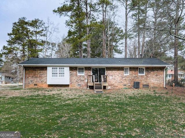 back of house with central AC and a lawn