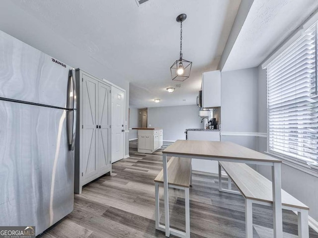 525 Henson Cir, Carrollton, GA 30117 - kitchen with appliances with stainless steel finishes, wood finished floors, baseboards, and hanging light fixtures