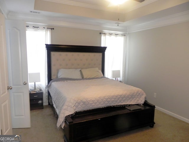 bedroom featuring a raised ceiling, ornamental molding, and light colored carpet