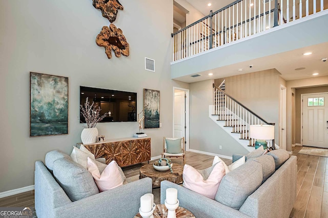 living room with hardwood / wood-style flooring and a high ceiling