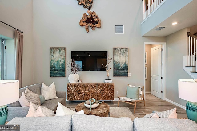 living room featuring hardwood / wood-style flooring and a towering ceiling