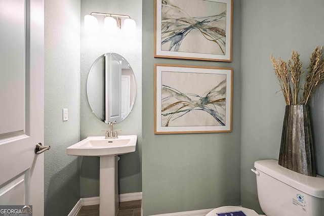 bathroom with wood-type flooring and toilet