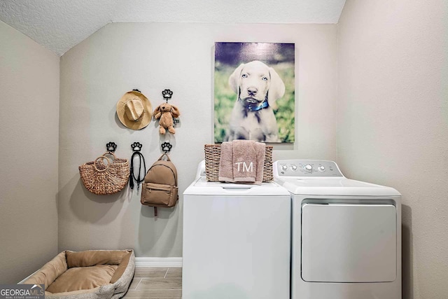 laundry room featuring separate washer and dryer and a textured ceiling