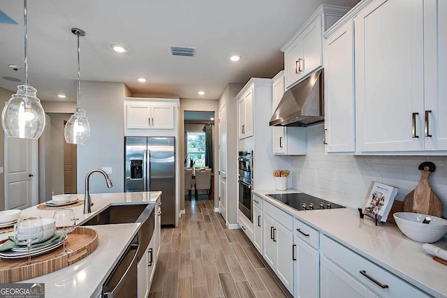 kitchen featuring sink, white cabinetry, hanging light fixtures, backsplash, and stainless steel appliances