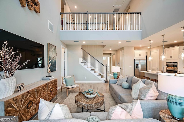 living room featuring a towering ceiling and hardwood / wood-style floors