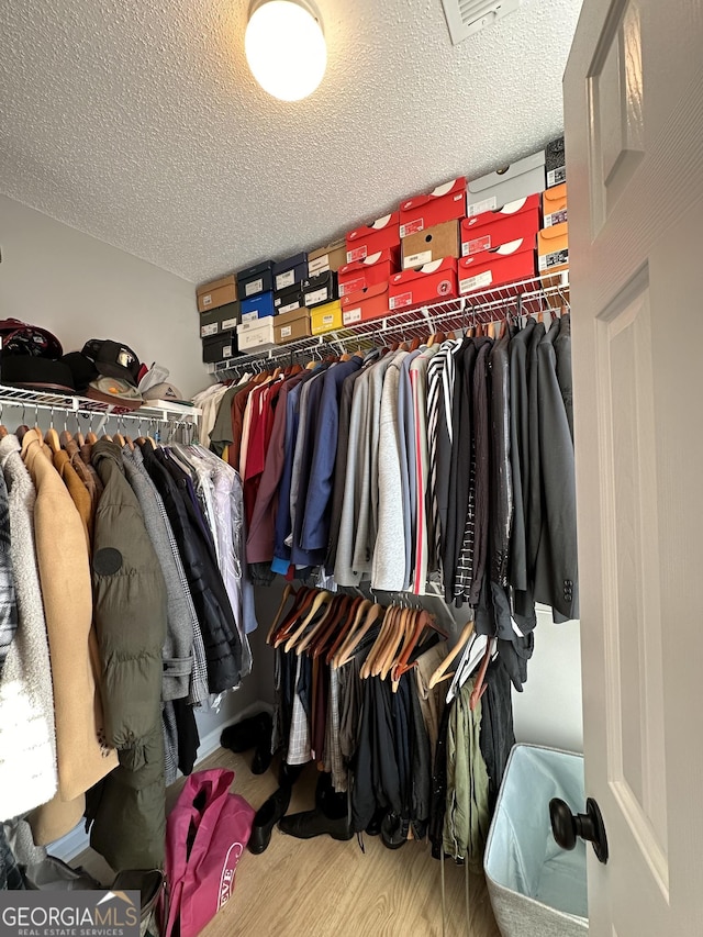 walk in closet with hardwood / wood-style floors