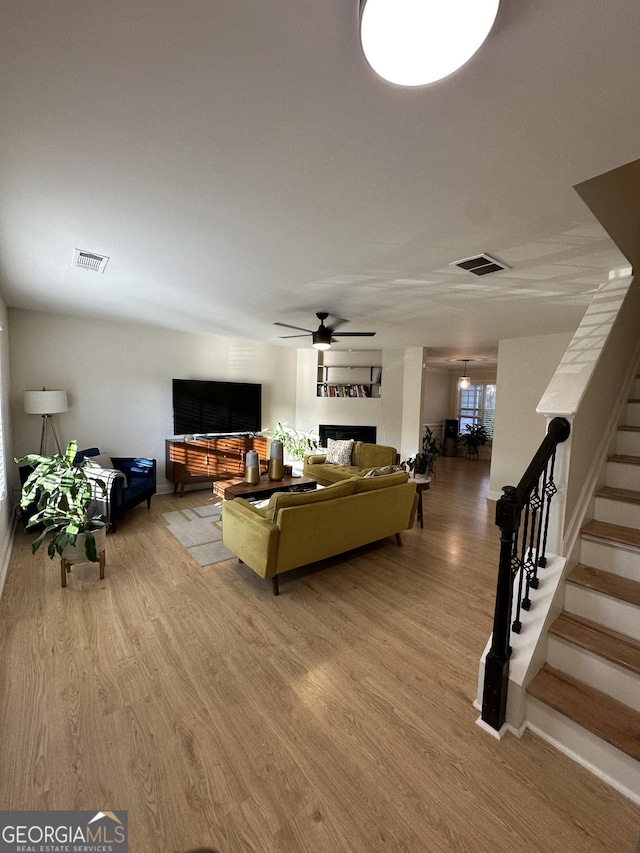 living room featuring wood-type flooring and ceiling fan