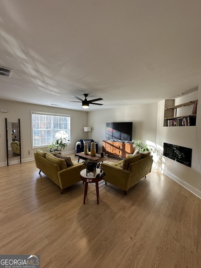 living room with ceiling fan and light hardwood / wood-style flooring