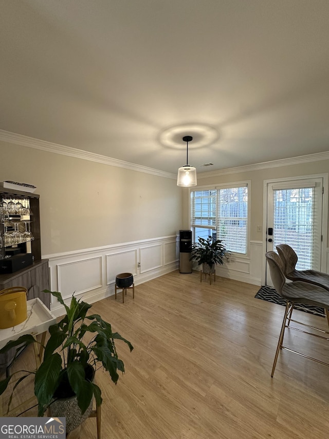 interior space with ornamental molding and light hardwood / wood-style floors