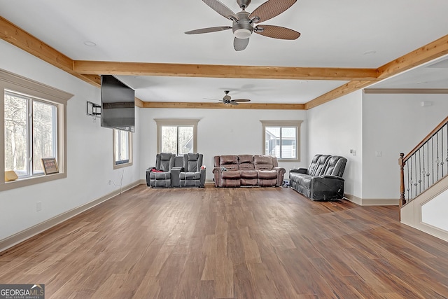 unfurnished living room featuring a wealth of natural light, hardwood / wood-style floors, and beam ceiling