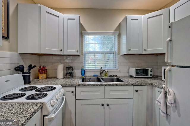 kitchen featuring sink, white appliances, decorative backsplash, and white cabinets